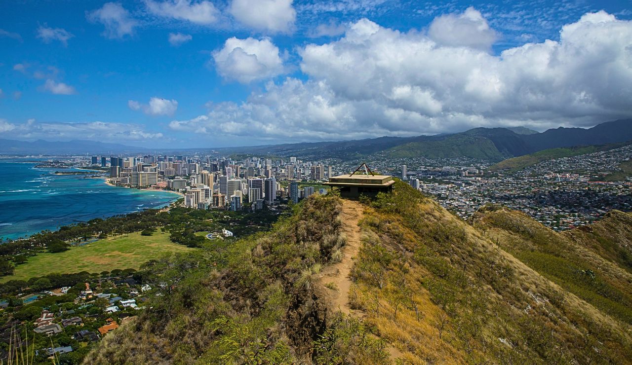 Low volcanic ridge with distant mountain slopes near the ocean.