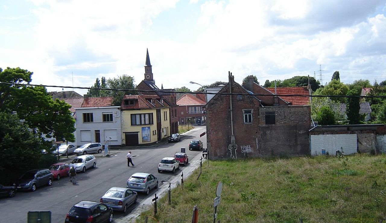 Abandoned house in Doel, Belgium with street view and church in background.