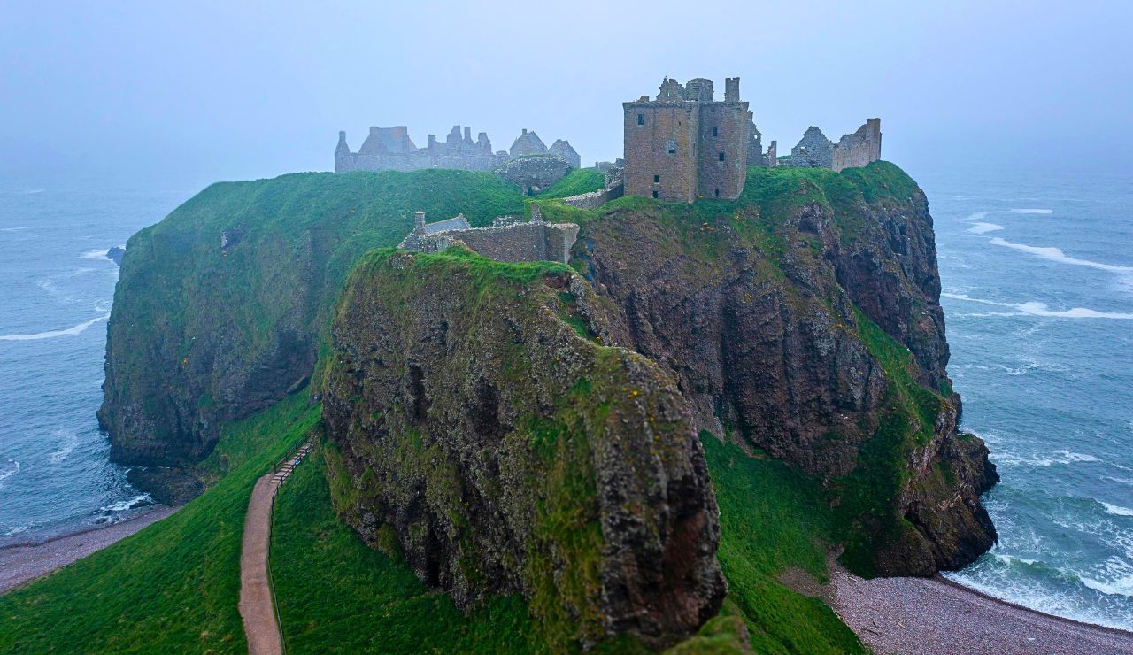 Cliffside medieval ruins above crashing ocean waves