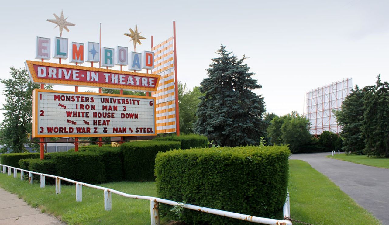 Elm Road Drive-In Theatre marquee showing films like Monsters University, Iron Man 3, and World War Z, with a large screen in the background.