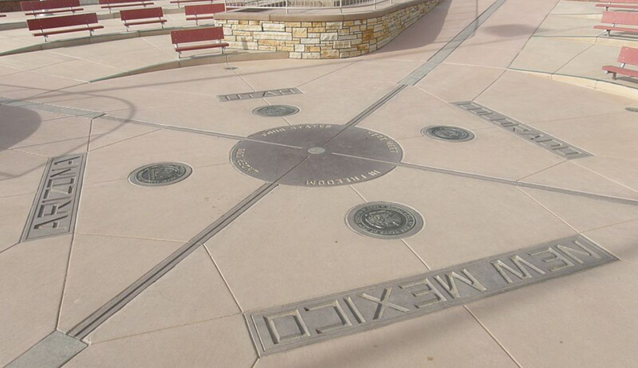 Four Corners Monument marking the intersection of Arizona, Colorado, New Mexico, and Utah, with state lines and seals engraved on a concrete plaza.