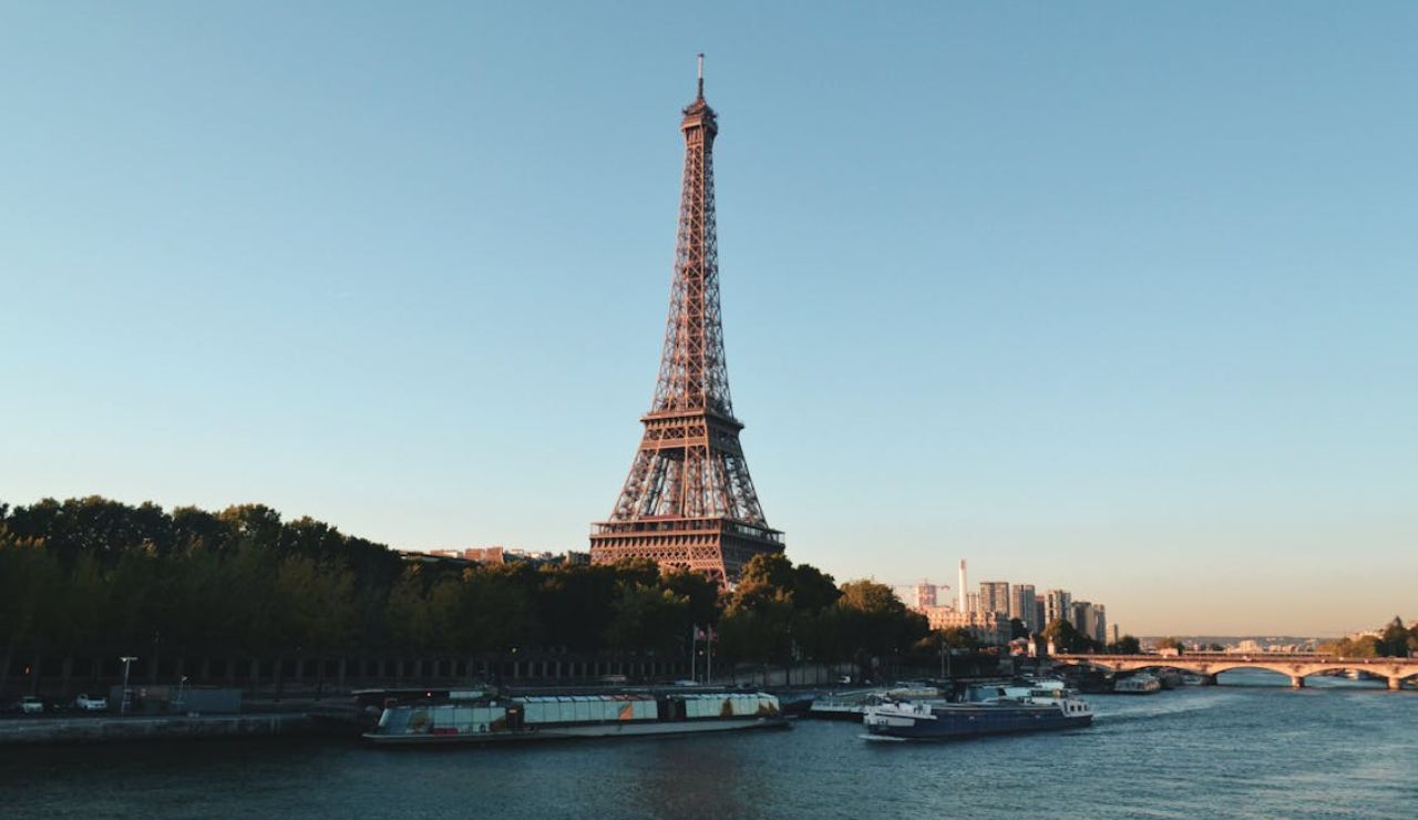 Eiffel Tower overlooking the Seine River with boats and cityscape in Paris, France.