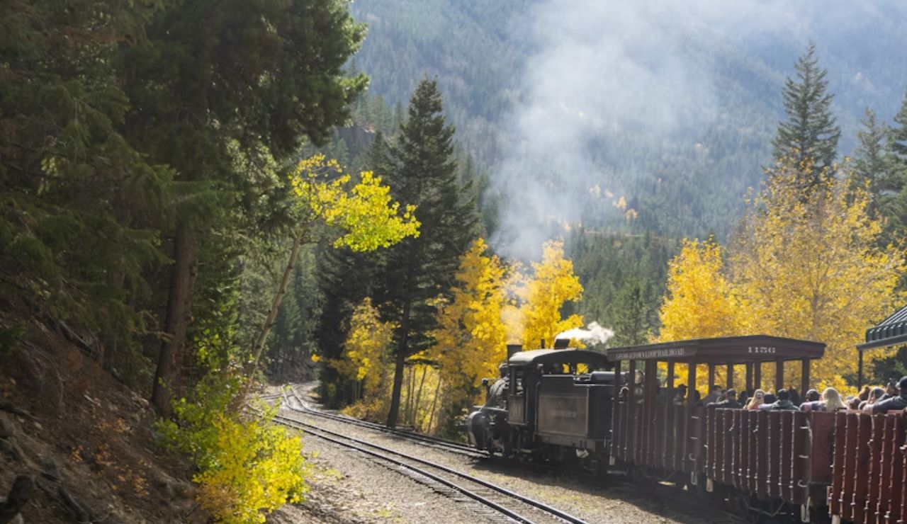 Historic steam train passing through fall foliage in the Rocky Mountains near Georgetown, Colorado.