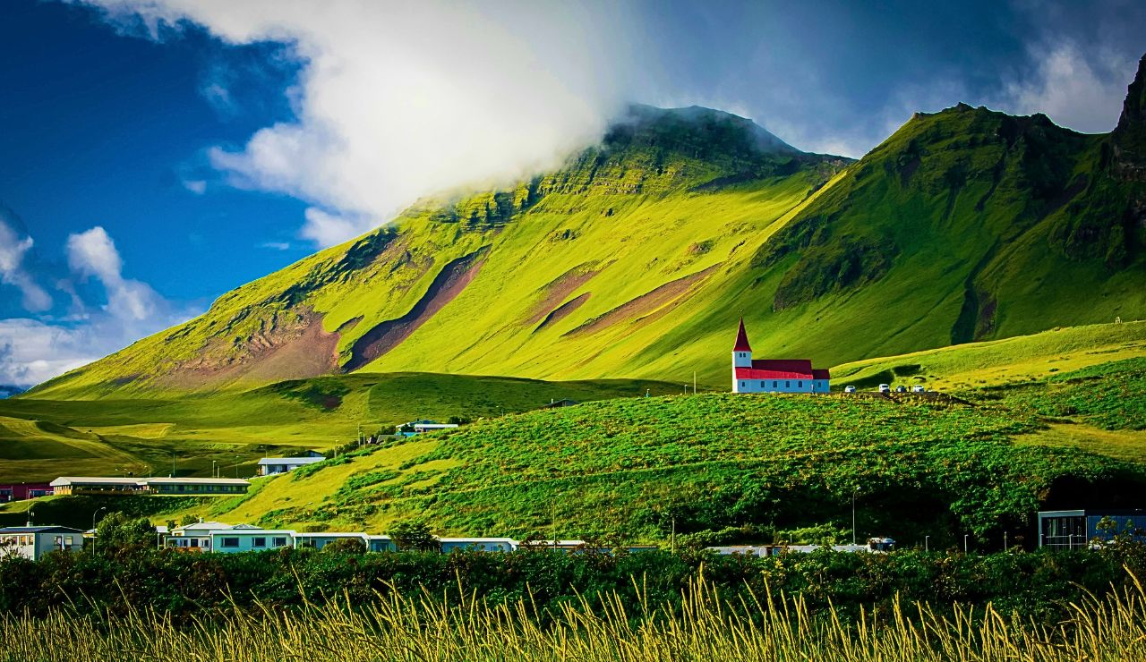 green space with mountains and volcanic backdrop in Iceland.
