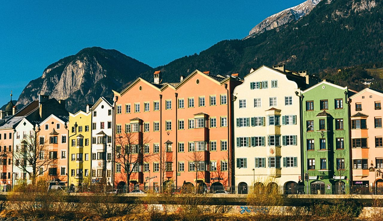 Colorful buildings of Innsbruck’s Old Town with snowcapped Alps in the background, blending history with alpine adventure.