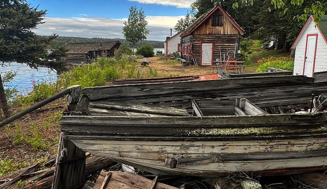 Old wooden boat and rustic cabins along the shoreline at Isle Royale National Park, Michigan.