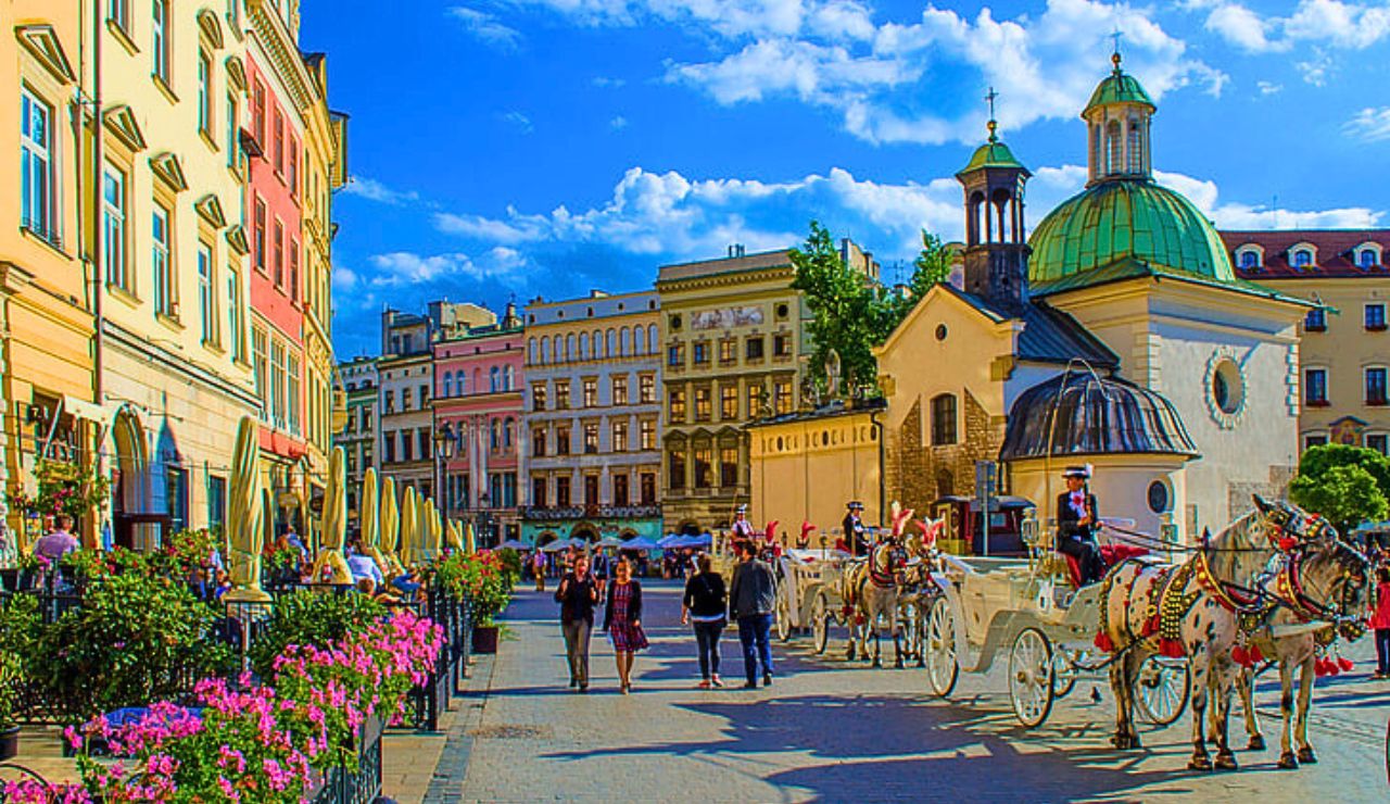 Sunset over Kraków’s Main Market Square with cafes and historic architecture.