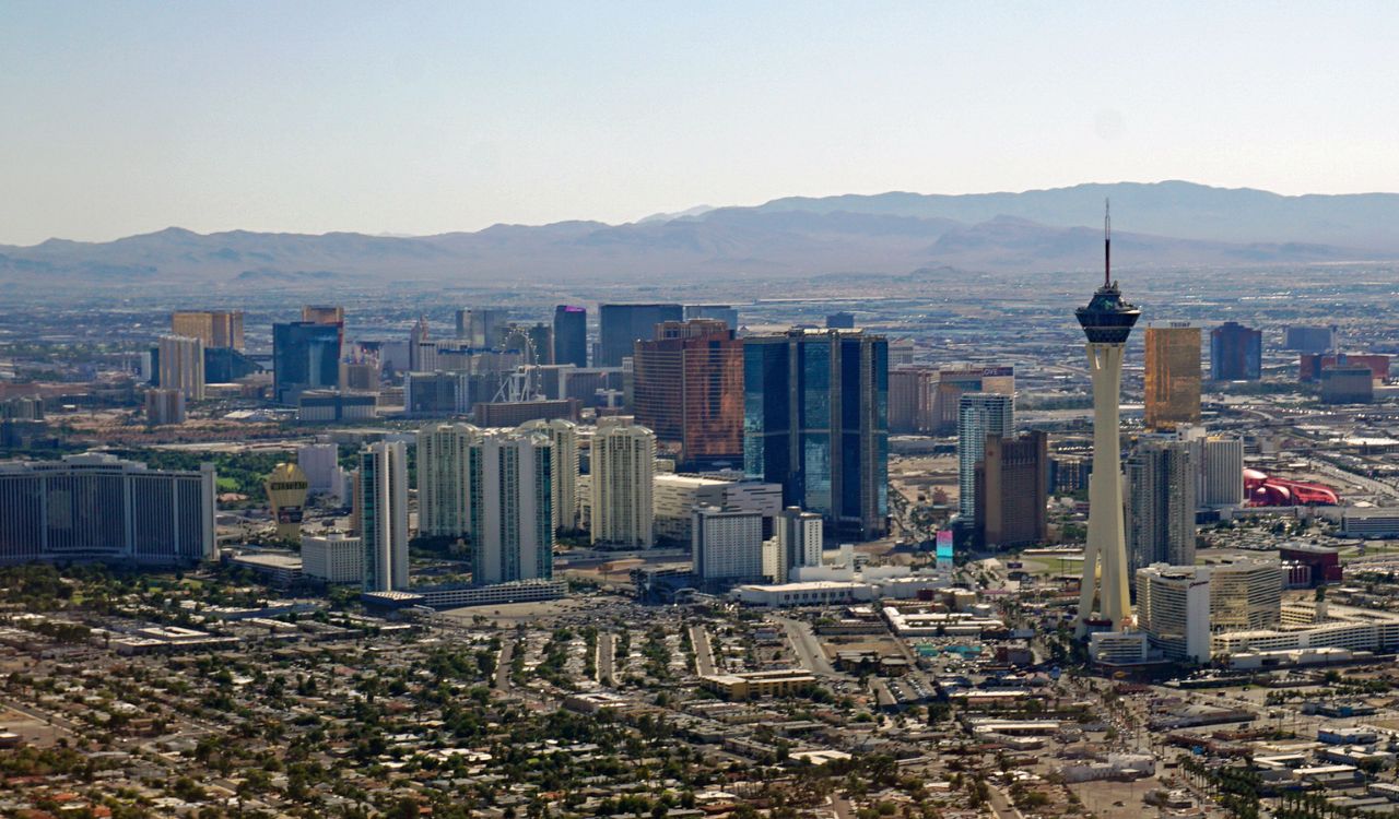 Desert city skyline with tall towers and modern buildings under a clear sky.