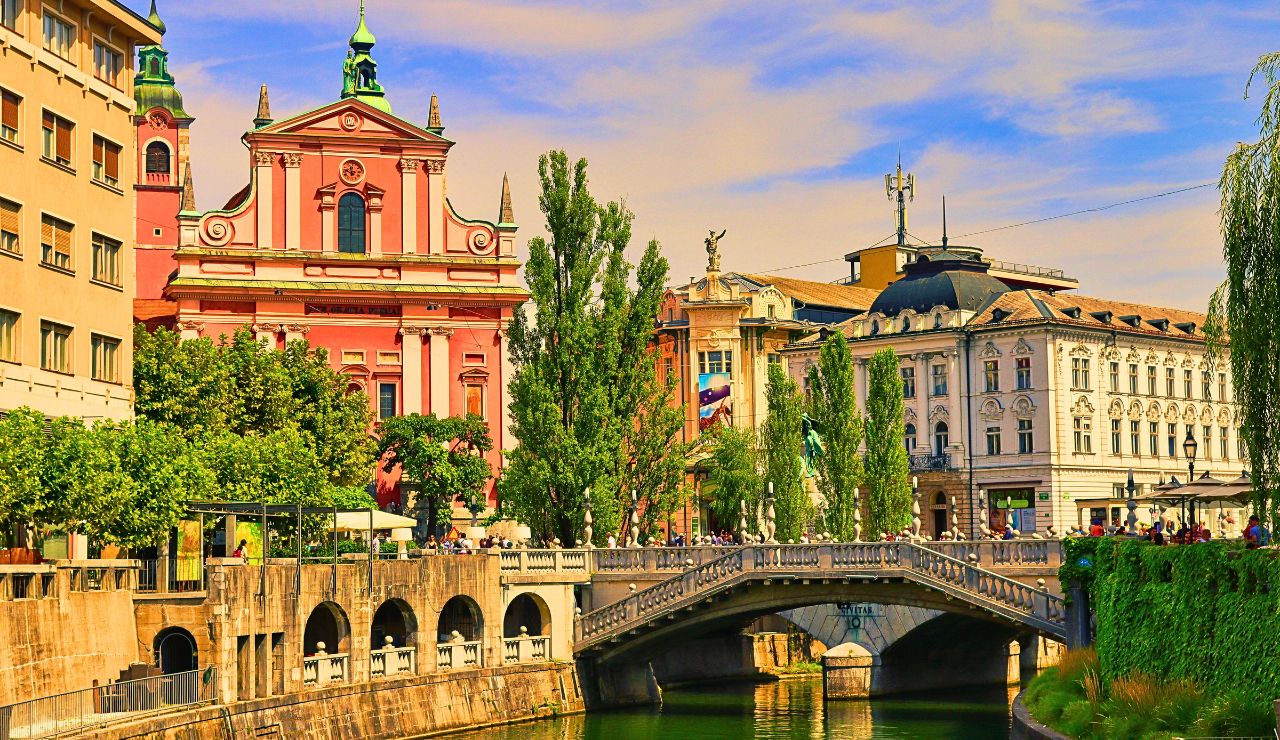 Colorful riverside buildings and footbridges in Ljubljana.