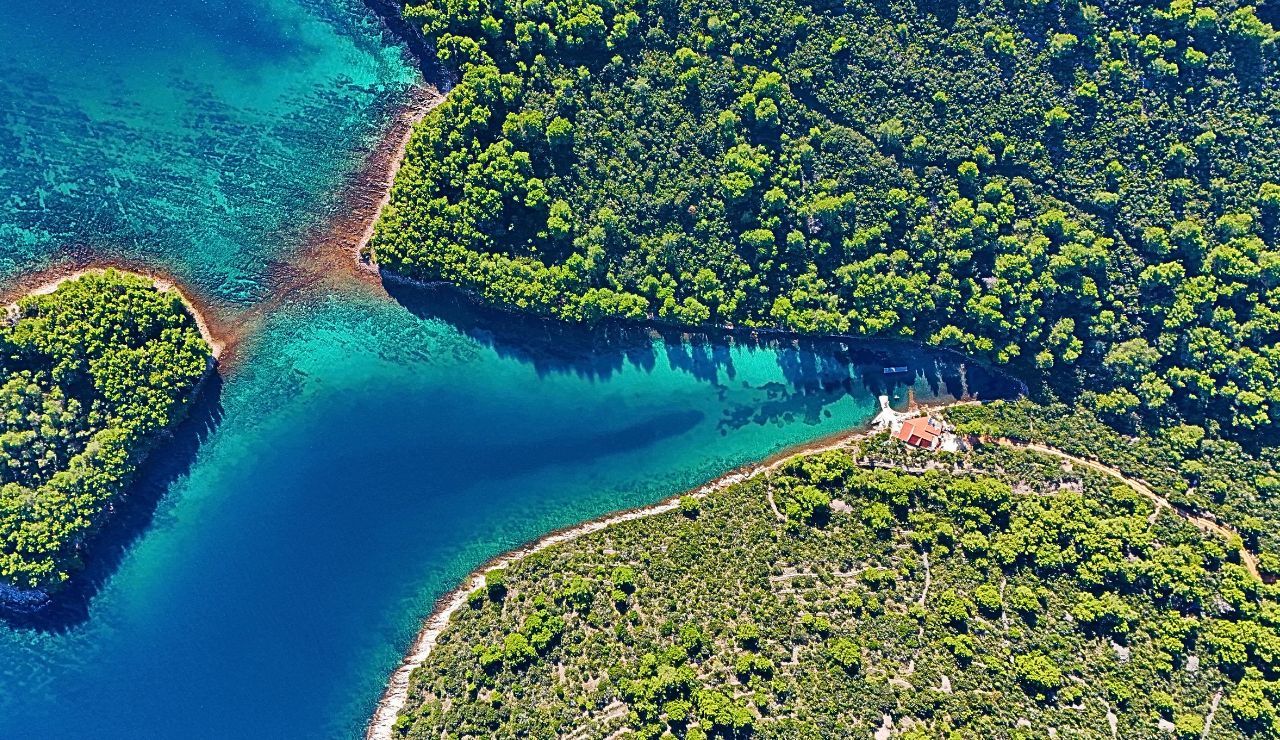 Monastery sits on an islet in a turquoise lake on forested Mljet Island.
