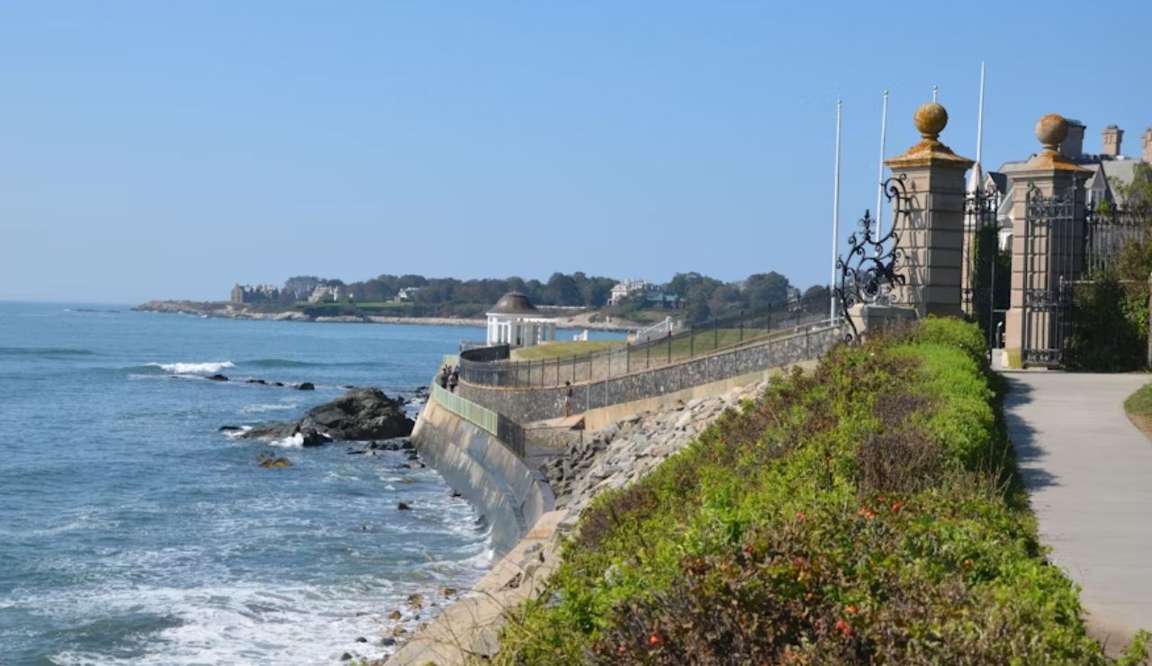 Oceanfront walkway along the Newport Cliff Walk in Rhode Island with waves and historic mansions.