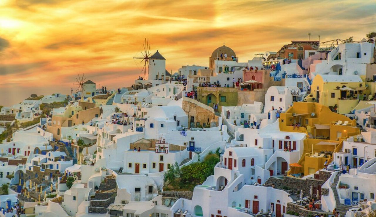 Santorini's whitewashed houses and windmills at sunset in Oia, Greece.