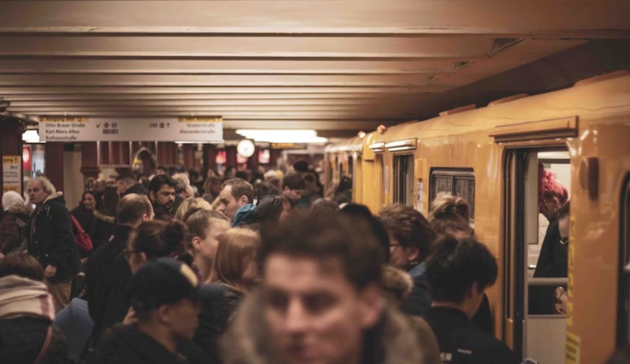 Crowded subway platform with passengers boarding yellow train during rush hour.