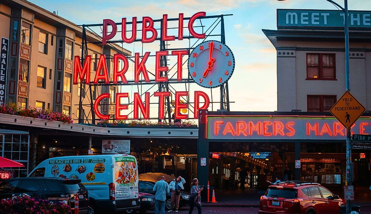 Exterior of Pike Place Market with red sign and street stalls
