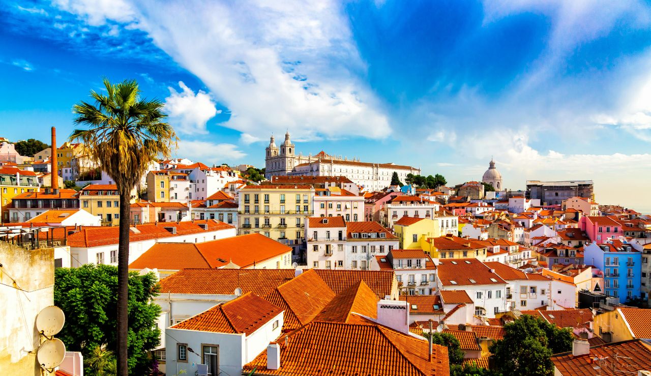 A yellow tram passing through Lisbon's historic district.