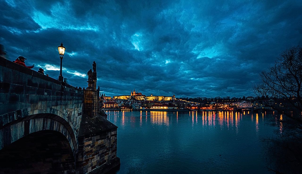 Charles Bridge and historic buildings under soft morning light in Prague.
