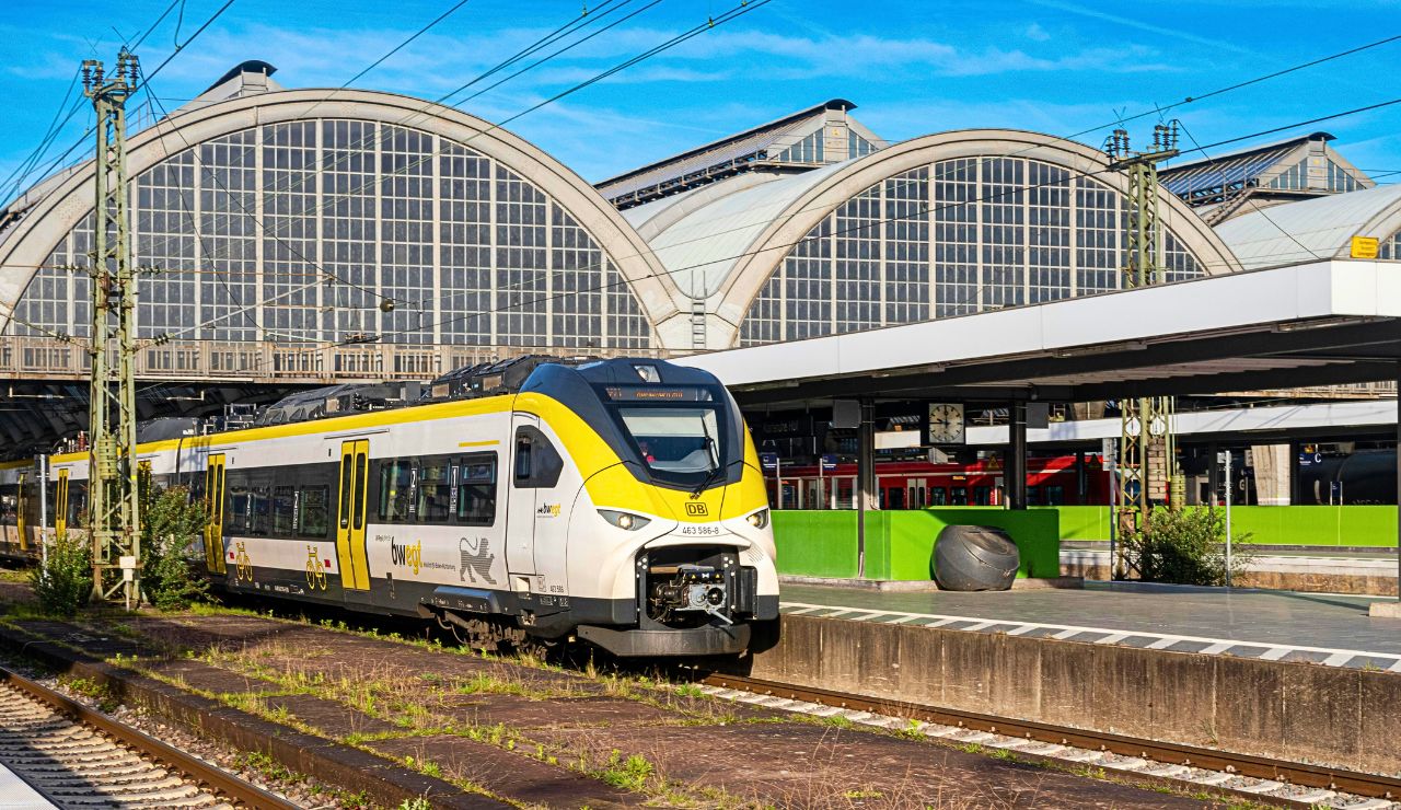 A modern AVE train next to a smaller regional train on separate tracks at a sunlit station. 3. Use Spain’s Renfe App for Smooth Travel
