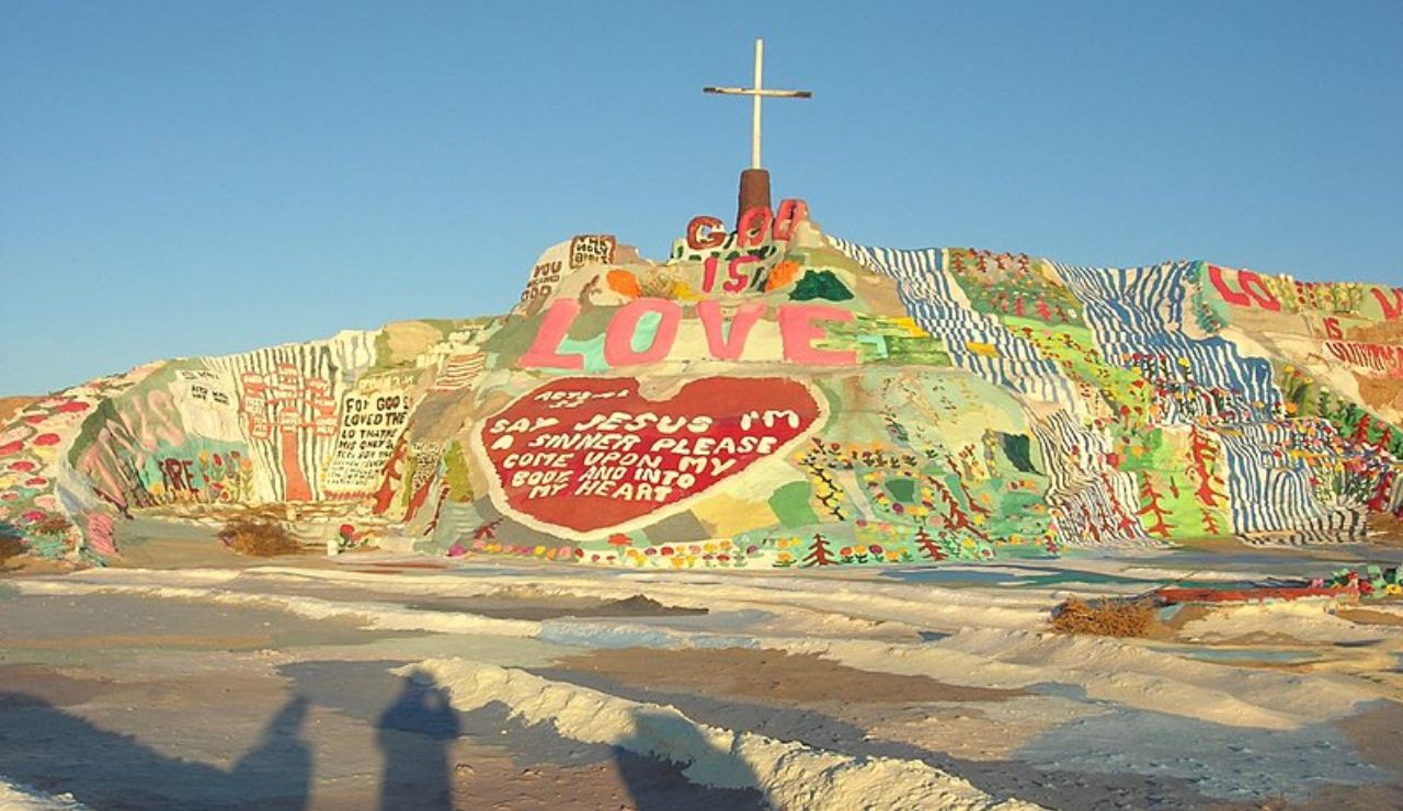Salvation Mountain in California’s Colorado Desert, a colorful hillside art installation featuring religious messages, painted murals, and a white cross at the top.