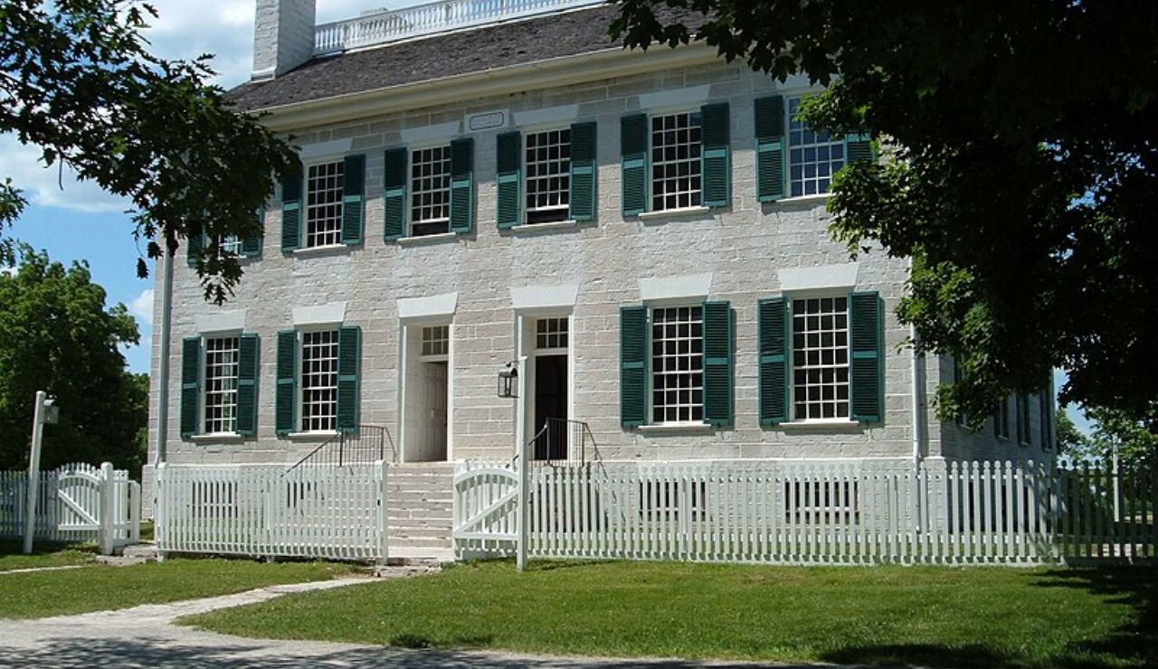 Restored white brick Federal-style building with green shutters at Pleasant Hill Shaker Village, Kentucky.Restored white brick Federal-style building with green shutters at Pleasant Hill Shaker Village, Kentucky.