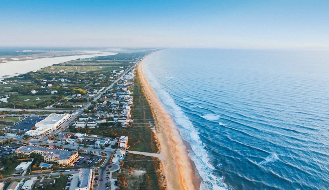 Aerial view of St. Augustine Beach, Florida, with ocean waves and coastal homes.