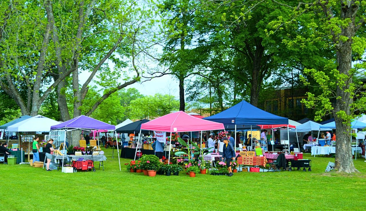 Open-air town square with music stage and market tents