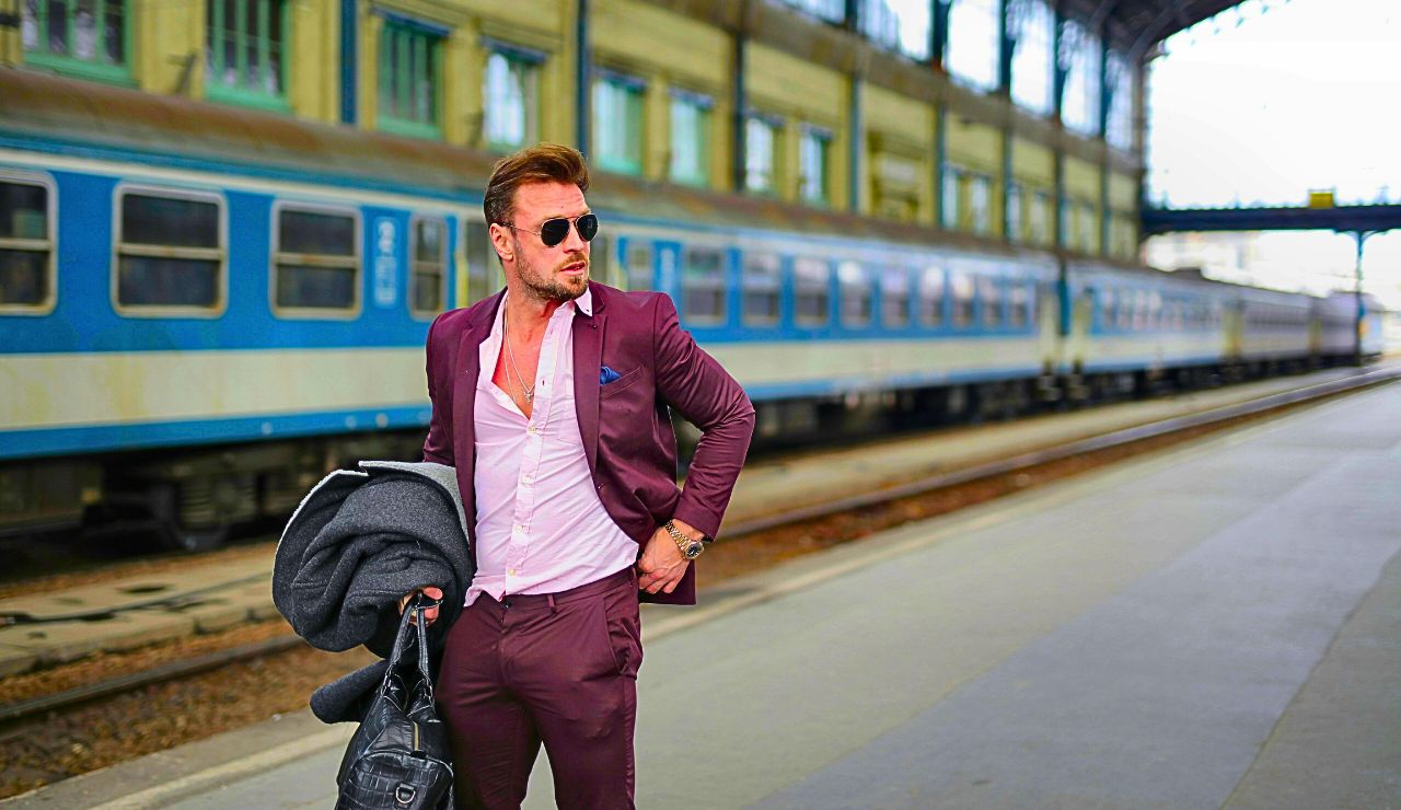 A traveler with a bag before boarding a Renfe AVE train.