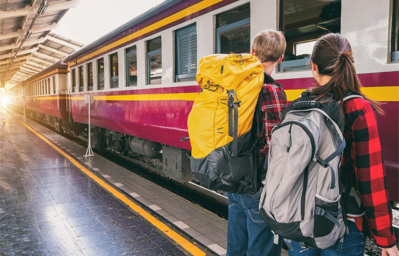 Backpackers waiting at a train station.