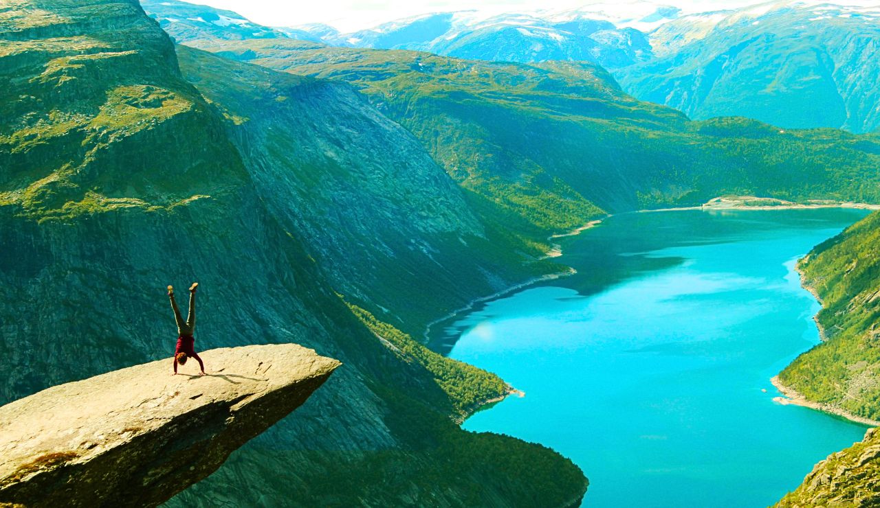 Sheer Nordic cliffs overlooking snowy mountain peaks and a deep valley.