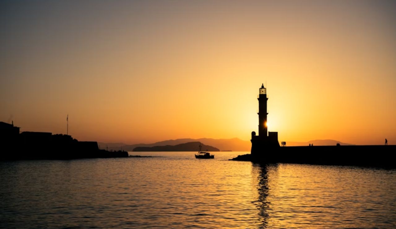 Silhouette of Chania lighthouse at sunset in Crete, Greece.