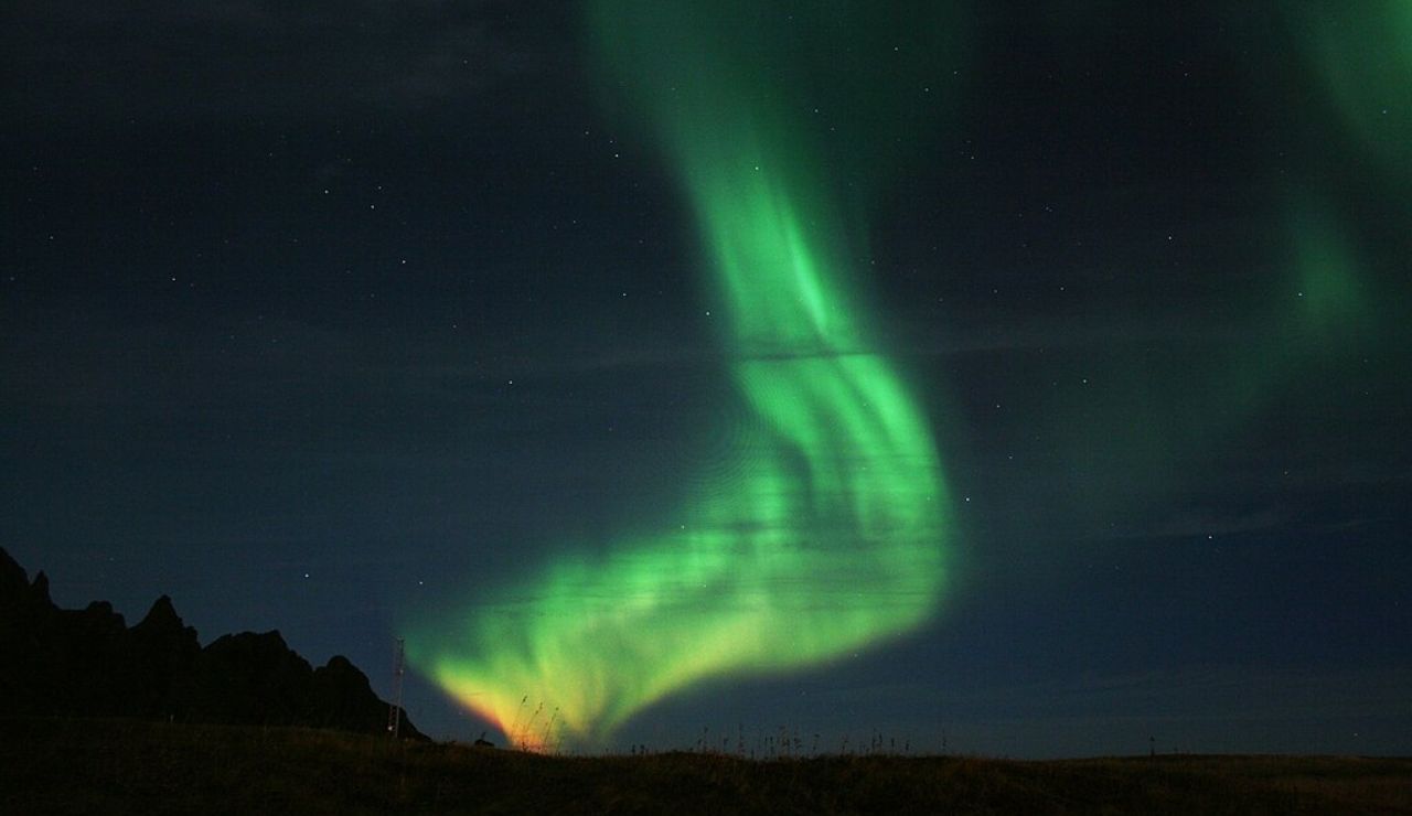 Northern lights swirling in the night sky above the landscape of Vesterålen, Norway.