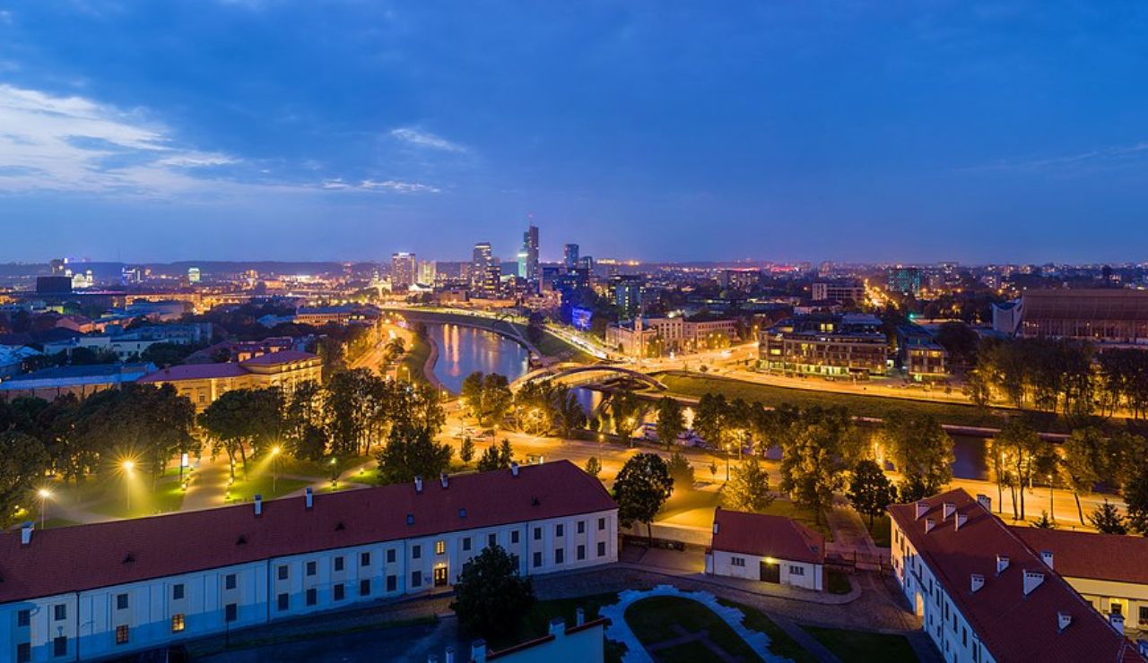 Vilnius cityscape at dusk with Neris River and modern skyline, Lithuania.