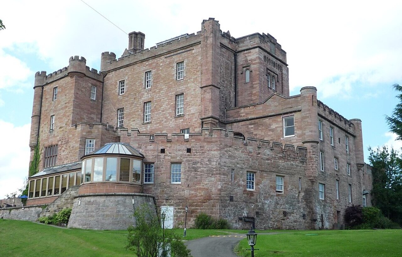 Dalhousie Castle exterior with stone walls and turret in Scotland.