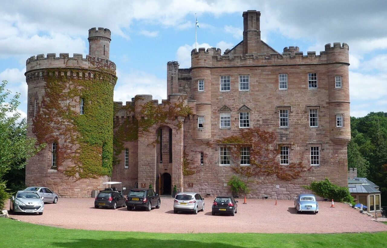 Dalhousie Castle with parked cars in Scotland.