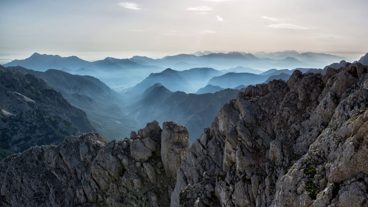 Misty mountain peaks in Japan, with rugged terrain and a soft, atmospheric light creating a painting-like effect