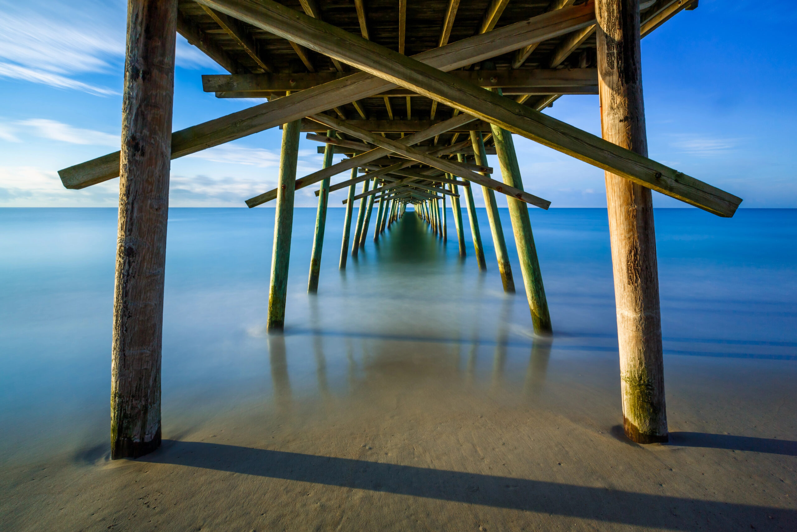 View from under a dock in Emerald Isle, leading to the ocean.