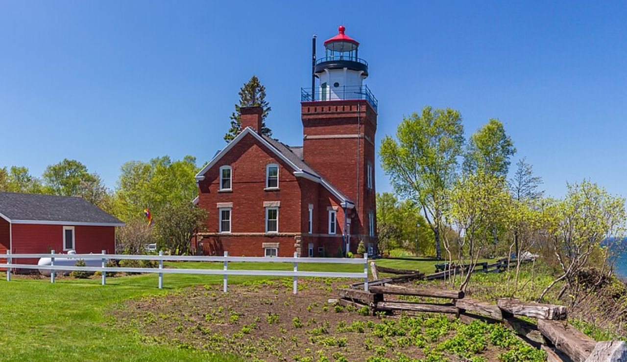 Big Bay Point Lighthouse in Michigan, a red brick tower with attached house near Lake Superior.