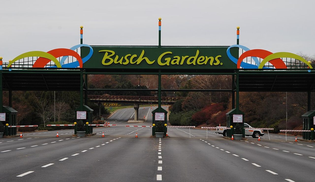 Entrance toll booths and colorful sign at Busch Gardens theme park on a cloudy day.