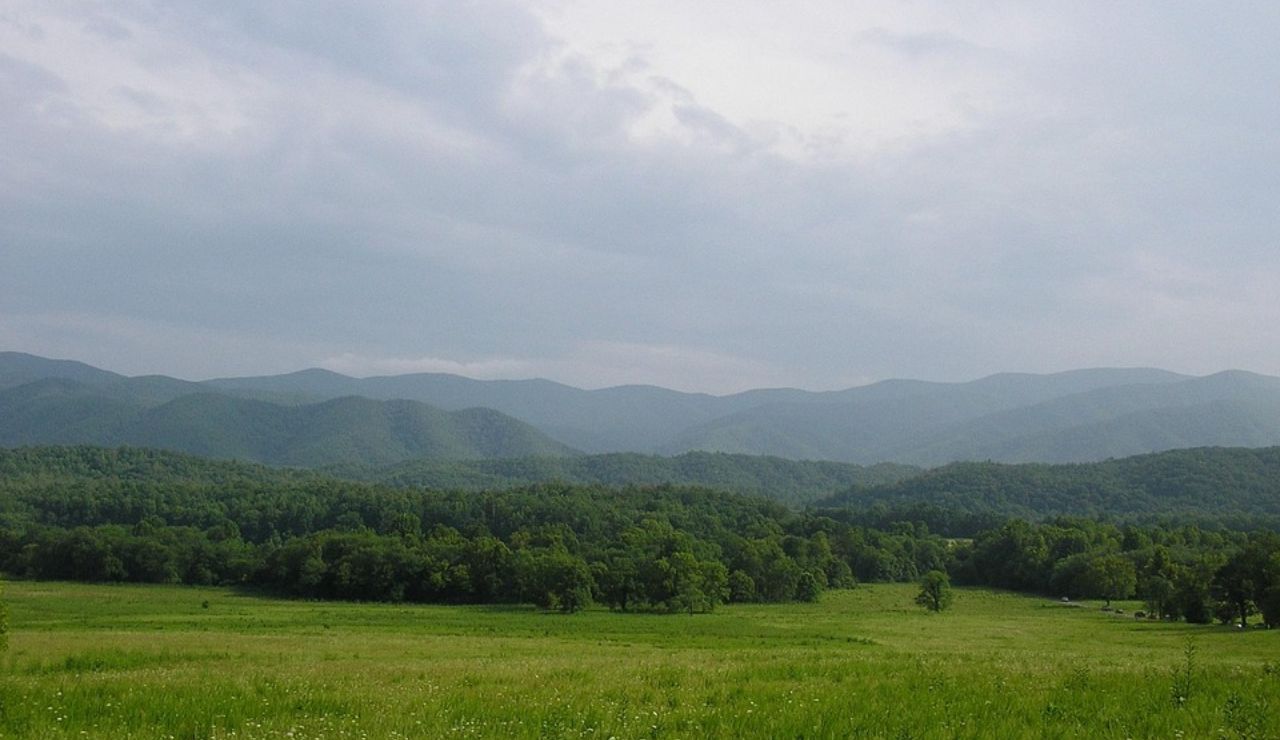Peaceful meadows and forested hills stretch across Cades Cove in Tennessee’s Smoky Mountains.
