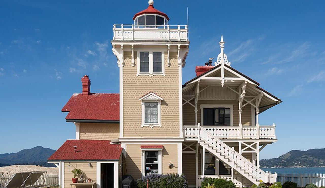 East Brother Light Station in California with red roof, beige exterior, and Victorian-style architecture overlooking the bay.