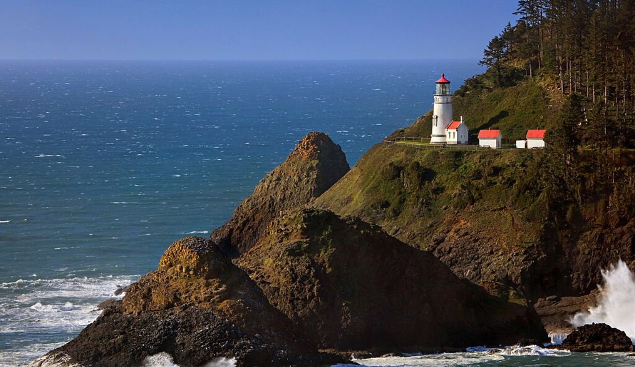 Heceta Head Lighthouse perched on a rocky Oregon coast with waves crashing below.