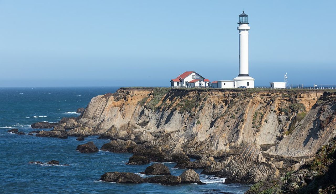 Point Arena Lighthouse in California perched on rugged coastal cliffs overlooking the Pacific Ocean.