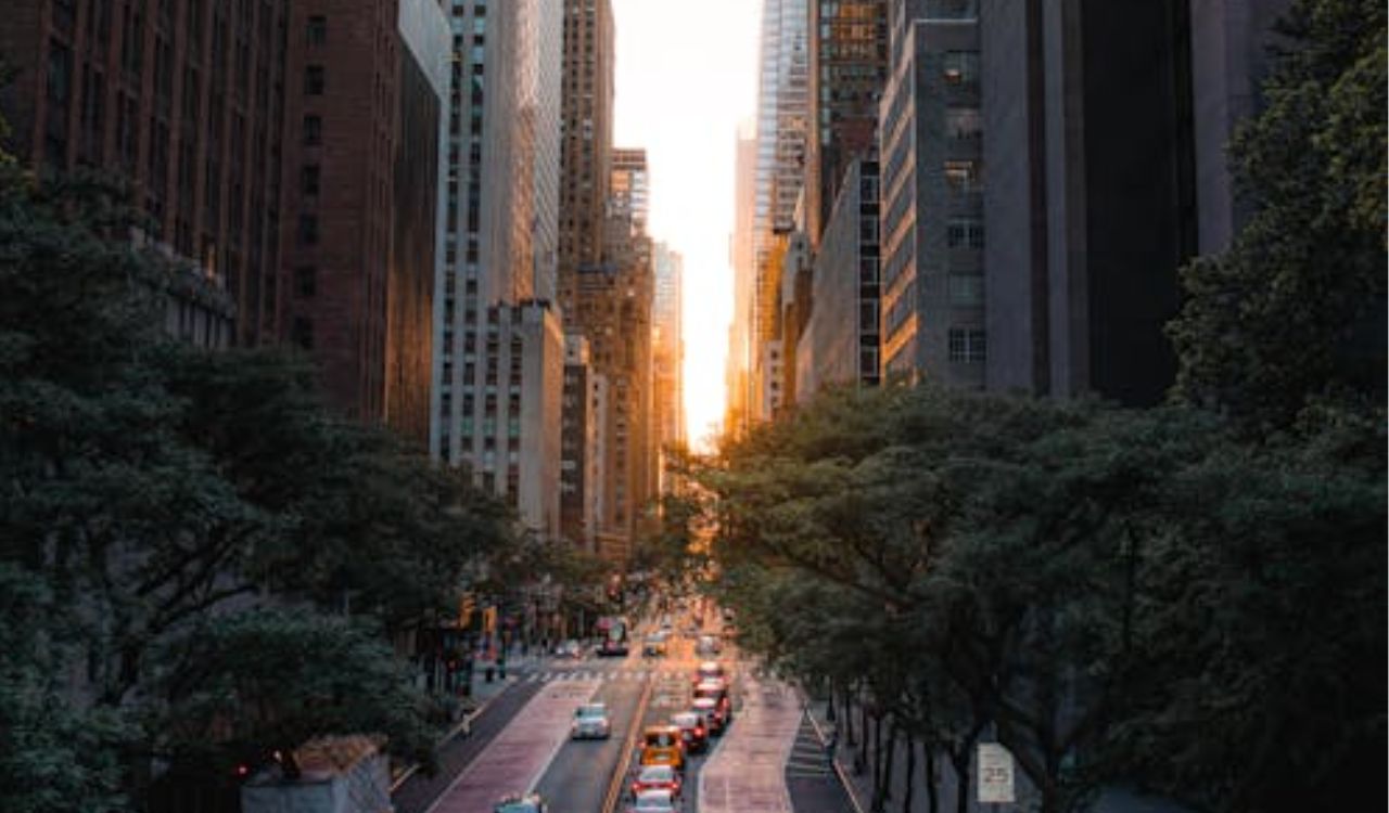 Busy city street lined with skyscrapers during sunset, symbolizing tourists sticking only to big cities and missing hidden gems