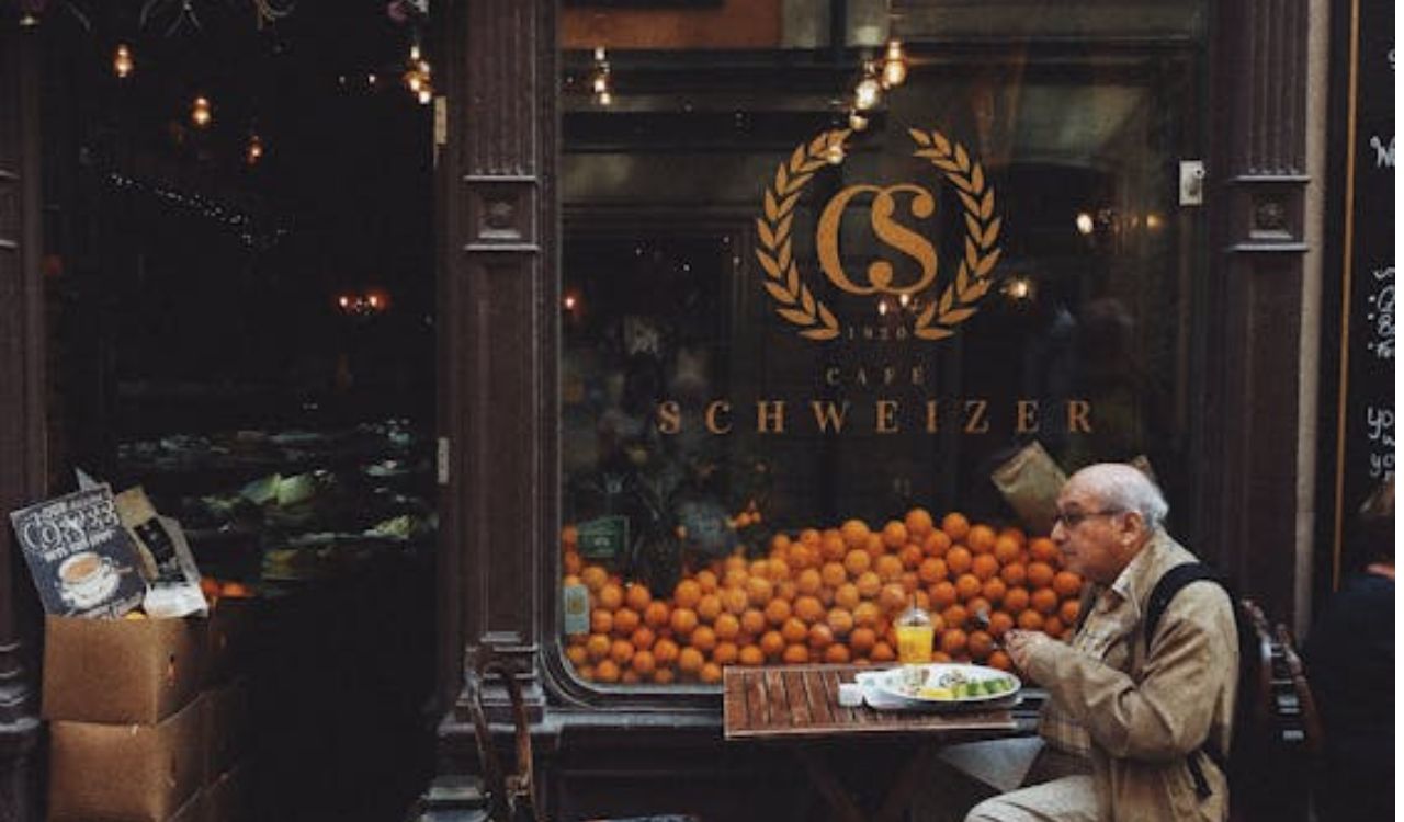 Elderly man enjoying a meal outside a local café, highlighting the charm and authenticity of street food culture