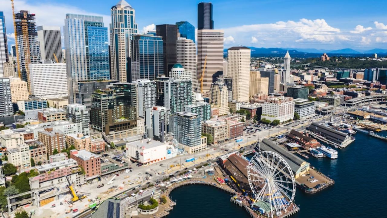 Aerial view of downtown Seattle, Washington, featuring the waterfront, skyscrapers, and the Seattle Great Wheel on a clear day.
