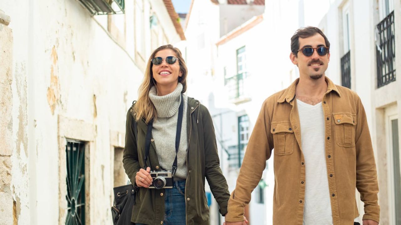 Smiling couple exploring a charming local neighborhood while traveling