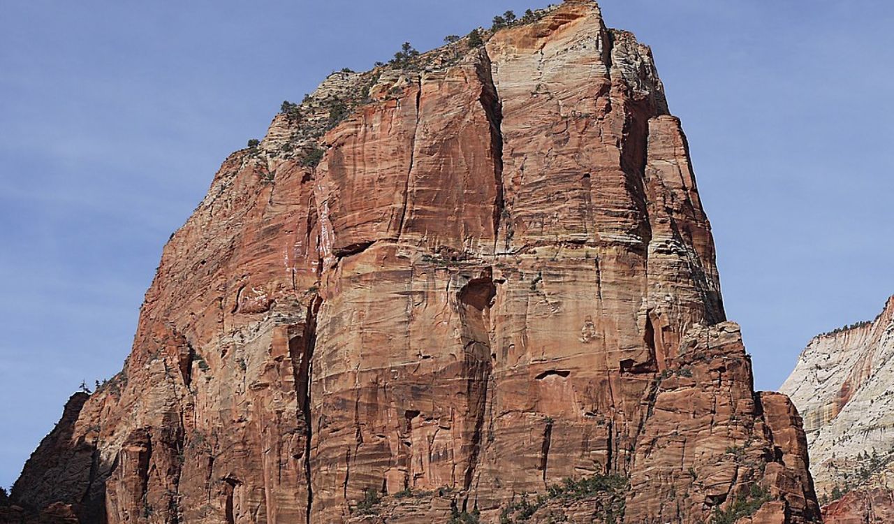 Angels Landing, a tall red rock formation in Zion National Park under a clear blue sky