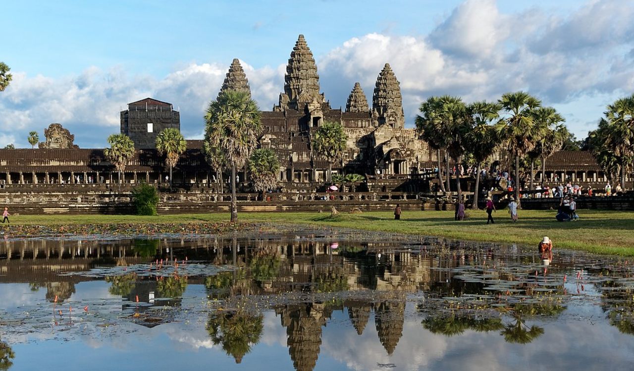 Angkor Wat temple in Cambodia, reflected in water with visitors walking around. Angkor Wat temple in Cambodia, reflected in water with visitors walking around. Angkor Wat temple in Cambodia, reflected in water with visitors walking around.