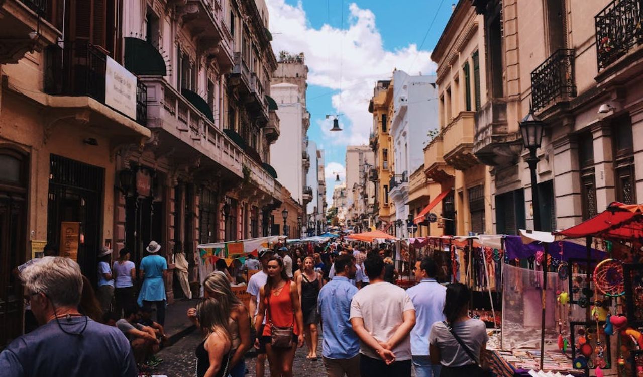 Crowded street market in Argentina with colorful stalls and old buildings