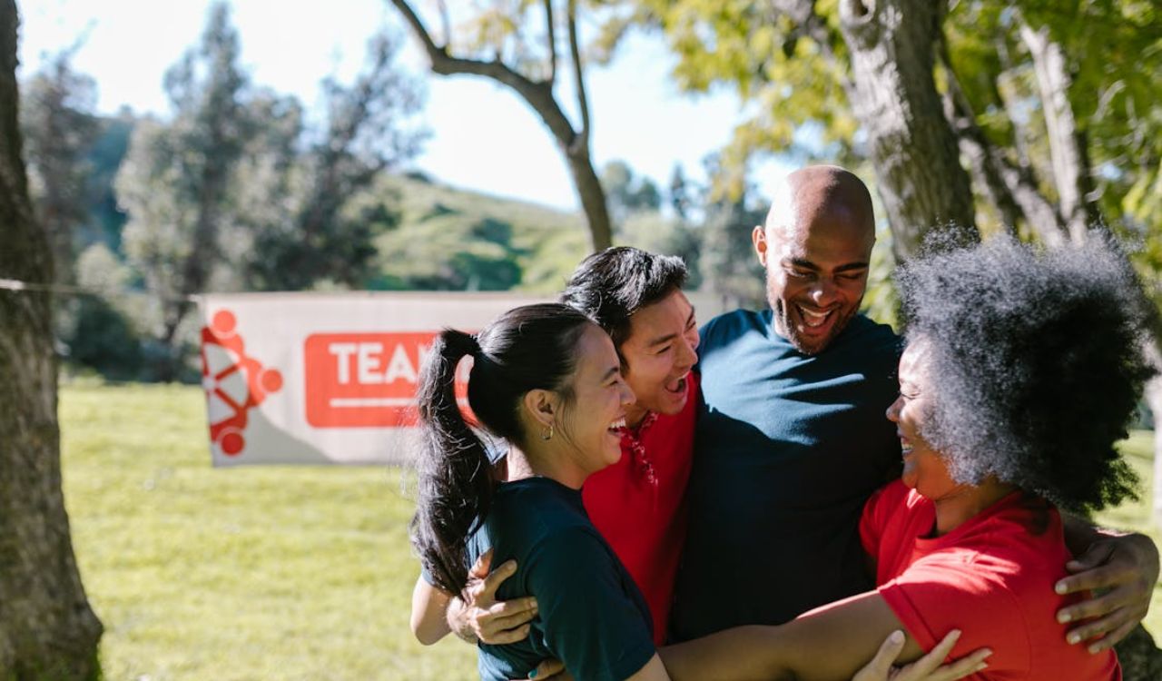 Group of happy people hugging at an outdoor cultural or team event