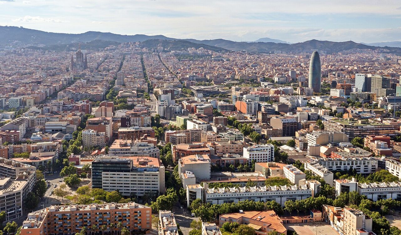 Aerial view of Barcelona with city grid layout and Sagrada Família in the distance